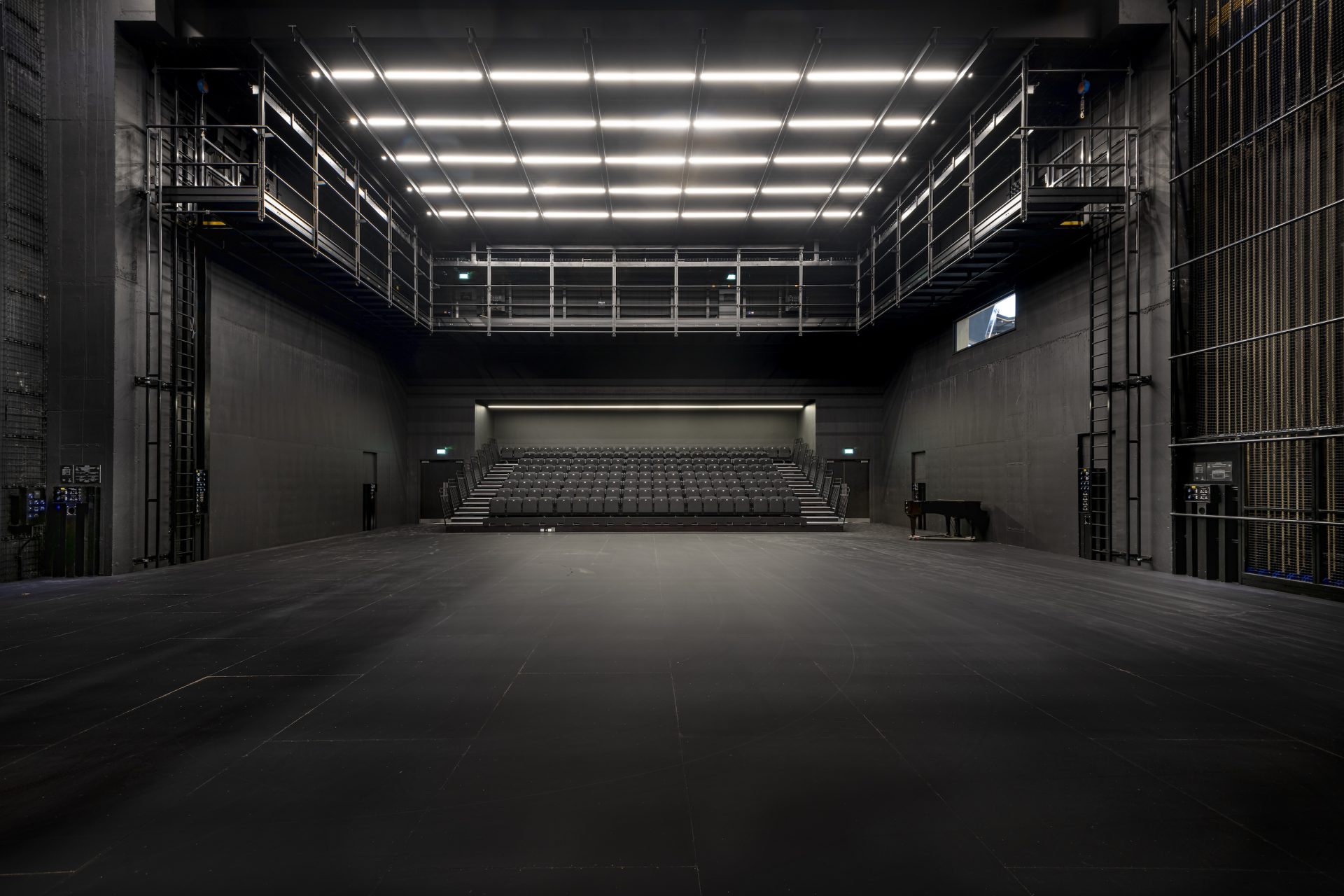A production studio rental space, with black walls and seating at the back.